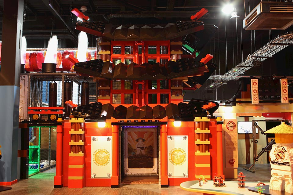 Colourful Chinese pagoda structure designed for children's play area, featuring intricate architectural details and vibrant red and gold colours.