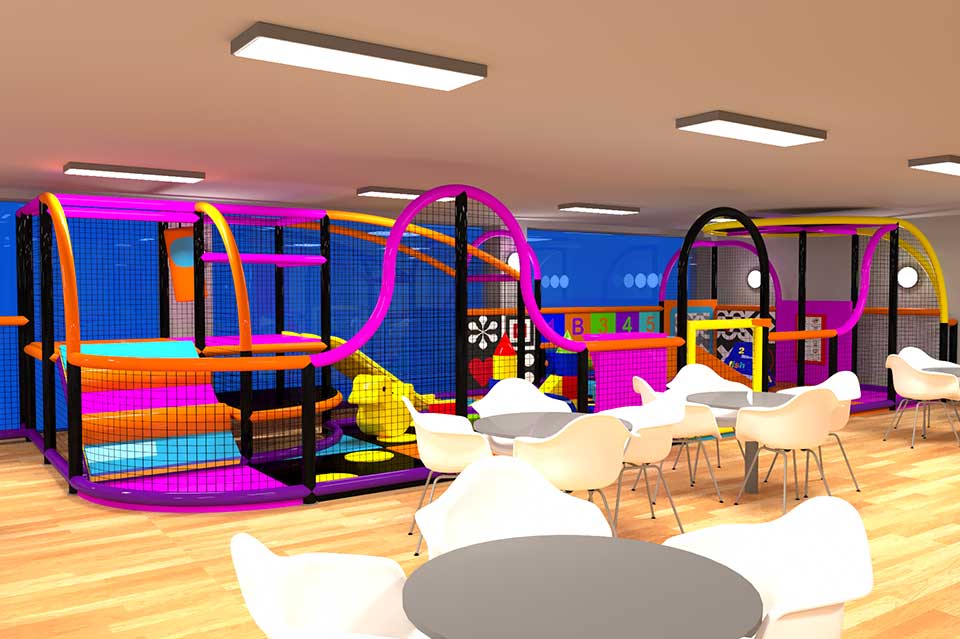 Brightly coloured indoor play area featuring a large soft play structure with slides and climbing frames, surrounded by seating areas with white chairs and tables. Ideal for children's entertainment and family outings.