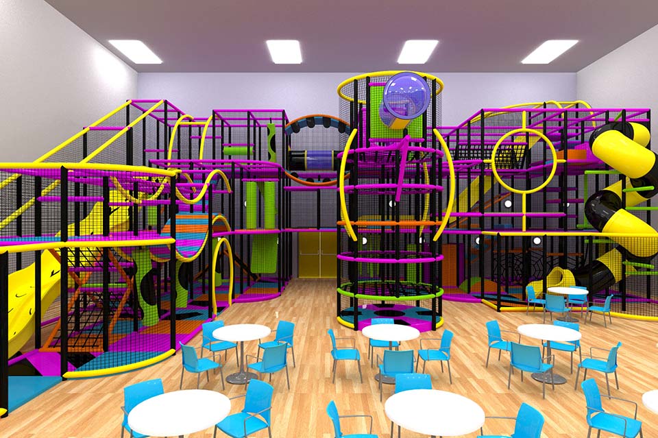 Indoor play area featuring colourful climbing frames and slides, designed for children's entertainment, with tables and chairs for parents and guardians.