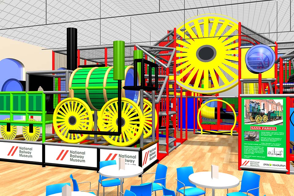 Colourful indoor play equipment featuring large yellow and green wheels, tubes, and climbing structures, designed for children's entertainment and physical activity in a vibrant play area.