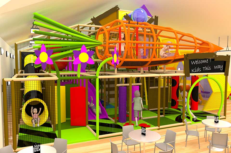 Colourful indoor play area featuring climbing structures, slides, and tunnels, designed for children's entertainment and physical activity. The vibrant design includes various play elements and seating for parents.